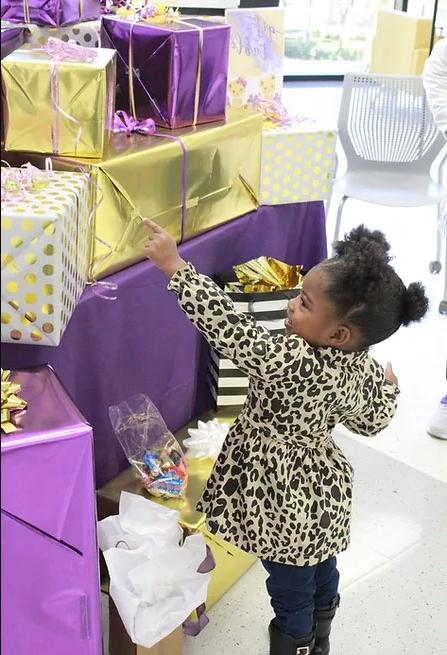 image of child with purple and gold wrapped presents